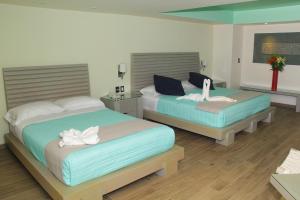 a bed room with two beds and a desk at Villas Maria Isabel in Santa Cruz Huatulco