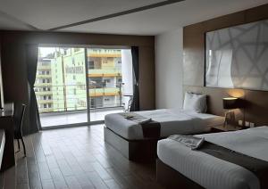a hotel room with two beds and a large window at The Vista Hotel By Satit Group in Sadao +219 photos
