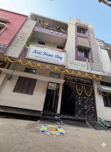 a building with a sign for a next home shop at Next Home Stay in Nalkhera