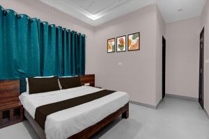 a bedroom with a bed with a blue curtain at Super Hotel O Kota Railway Junction Formerly Formerly Aagam Inn in Kota