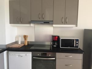 a kitchen with a counter top with a microwave at Sci Eden in Le Gosier