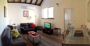 Kenata-Fairway في بيرث: غرفة معيشة مع أريكة وطاولة زجاجية