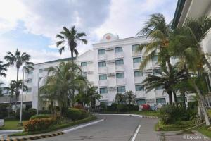 a large white building with palm trees in front of it at East Asia Royale Hotel in Lagao