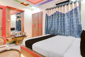 a bedroom with a bed and a desk and a mirror at Super Townhouse Lake Town Clock Tower Formerly Crown Comfort in Pātipukur