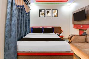 a bedroom with a bed and a couch and a television at Super Townhouse Lake Town Clock Tower Formerly Crown Comfort in Pātipukur +23 photos