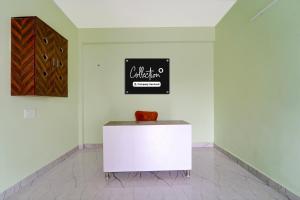 Un armario blanco en una habitación con un letrero en la pared. en Collection O MKU Madurai Formerly Mpl Elite, en Samayanallūr