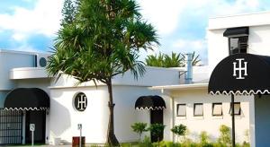 Un edificio blanco con una palmera delante. en Island Hotel Durban, en Isipingo Beach
