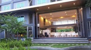 Una casa con una gran puerta de cristal con mesas y sillas. en A+ Hotel, en Ban Na Khwai