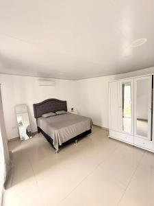 a bedroom with a bed in a white room at Casa en San Miguel, el salvador in San Miguel