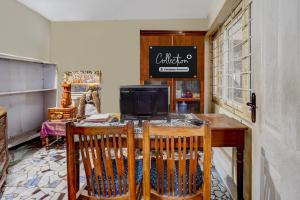 Una cocina con una mesa con una computadora encima. en Collection O Sunrise Point Serenity Beach Formerly White Lotus Residency, en Kottakupam