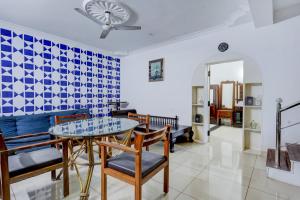 una sala de estar con una mesa y sillas en Collection O Sunrise Point Serenity Beach Formerly White Lotus Residency, en Kottakupam