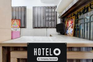a hotel sign on a desk in a room at Hotel O Rock Beachview Pondicherry Formerly Varsha Residency in Puducherry