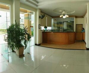 a lobby with a reception desk and a potted plant at Grand PL Ville Hotel in Phatthalung
