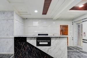 Una cocina blanca con una encimera con un cartel. en Townhouse Financial District Circle Hyderabad, en Gundipet