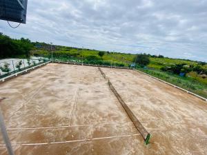 a tennis court with a net on top of it at Oasis Residency and Resorts in Solapur
