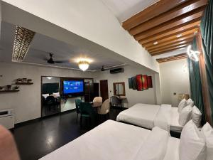 een hotelkamer met twee bedden en een televisie bij Karachi Fort Boutique Hotel in Karachi
