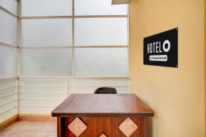 a table in a room with a sign on the wall at Hotel O Bidadi Railway Junction Bangalore Formerly Ejalla in Bidadi