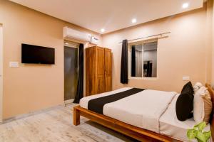 a bedroom with a bed and a flat screen tv at Super Collection O Puri Seaview Formerly Hotel Aavaas in Puri