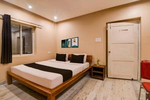 a bedroom with a bed and a window and a door at Super Collection O Puri Seaview Formerly Hotel Aavaas in Puri +22 photos