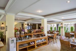 ein Restaurant mit Tischen und Stühlen und einer Theke mit Vasen in der Unterkunft Duta Garden Hotel in Yogyakarta