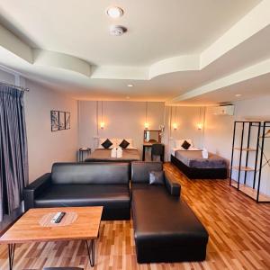 a living room with a couch and a bed at Viphuanan Resort in Nong Prue