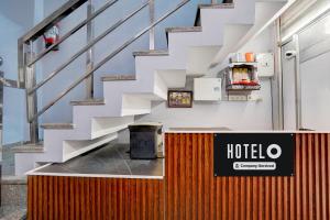 Una escalera en un edificio con un cartel de hotel. en Hotel O City Centre Rudrapur Formerly Yuvraj Guest House, en Rudrapur