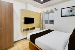 Una habitación de hotel con una cama y un televisor. en Collection O Kollur Prime Arena Formerly Hotel Krishna, en Kundakal