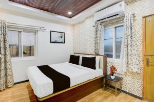 Un dormitorio con una cama y dos ventanas. en Collection O Kollur Prime Arena Formerly Hotel Krishna, en Kundakal 23 fotos más