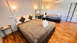 a hotel room with two beds and a phone at Viphuanan Resort in Nong Prue +41 photos