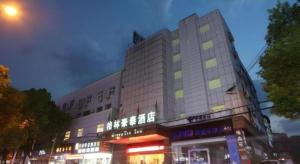 a tall building with neon signs in front of it at GreenTree Inn Xuancheng Jingxian Wannan First Street Express Hotel in Jingxian
