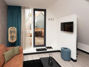 a living room with a couch and a television at Luxury apartment in Renesse with infrared sauna in Renesse