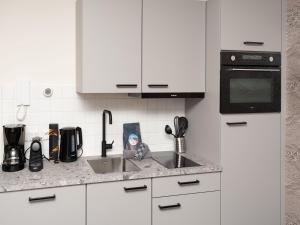 a kitchen counter with a sink and a microwave at Luxury apartment in Renesse with infrared sauna in Renesse