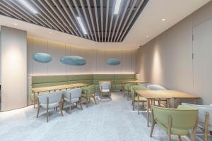 a dining room with wooden tables and chairs at JI Hotel Shanghai Pudong Airport Zhuqiao in Nanhui