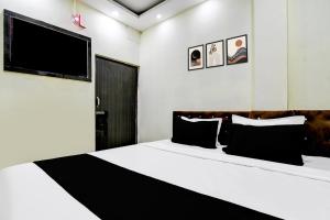 um quarto com uma cama e uma TV na parede em Hotel O Narayana RN Tagore Hospital Formerly Lantern Guest House em Calcutá