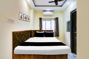 um quarto com uma cama grande e lençóis brancos e pretos em Hotel O Narayana RN Tagore Hospital Formerly Lantern Guest House em Calcutá