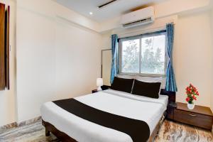 um quarto com uma cama grande e uma janela em Super Hotel O Khadakwasla Lakeview Formerly Gokul Lodge em Kharakvasla