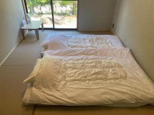 SEN.RETREAT TAKIJIRI في تانابا: سرير كبير في غرفة مع نافذة