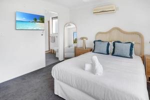 ゴールドコーストにあるPalm Springs Waterfront Retreat - Broadbeach Watersの大きな白いベッドと青い枕のある寝室