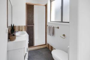 ゴールドコーストにあるPalm Springs Waterfront Retreat - Broadbeach Watersの洗面台とトイレを備えた白いバスルーム +21枚の写真