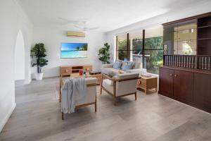 ゴールドコーストにあるPalm Springs Waterfront Retreat - Broadbeach Watersのソファとテーブルのあるリビングルーム