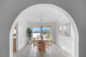 ゴールドコーストにあるPalm Springs Waterfront Retreat - Broadbeach Watersのテーブルと椅子のあるダイニングルーム