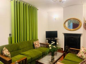 Una sala de estar con cortinas verdes y un sofá verde. en Lady Maccllum's Bungalow Stone Nuwareliya Sri Lanka, en Nuwara Eliya 14 fotos más