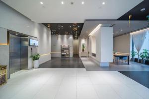 Jinjiang Inn Select Xuzhou Suning Plaza Jinguang East Road في سوزهو: لوبي مع غرفة مع طاولة وكراسي