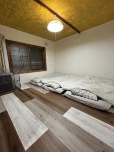 Dos camas en una habitación con suelo de madera. en Kame, en Niseko