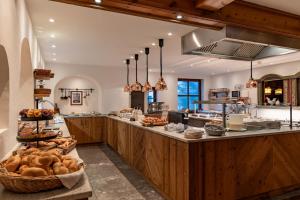 エールヴァルトにあるHotel Tirolerhof - Familotel Zugspitzeのたくさんの食べ物が並ぶカウンターのある広いキッチン