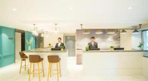 two men in suits sitting at a bar in an office at Magnotel Harbin Songbei Wanda Wenlvcheng in Harbin