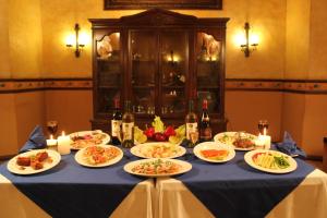 a table with plates of food and bottles of wine at Hotel Boutique La Mision De Fray Diego in Mérida