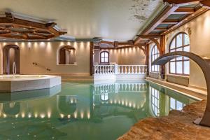 エールヴァルトにあるHotel Tirolerhof - Familotel Zugspitzeのスイミングプール付きの家の中にあるスイミングプール