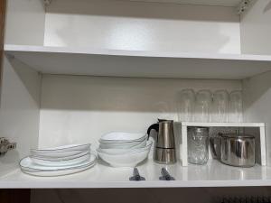 a shelf with plates and cups and dishes on it at Panoramic View apartment Seraidi Annaba in Annaba