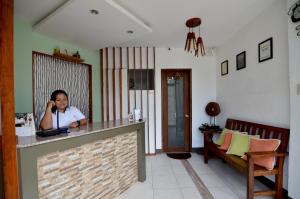 a woman sitting at a bar in a room at Highway to H Inn in Panglao Island